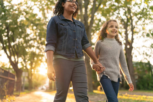 istock Smiling mother and daughter walking hand in hand 1218865387