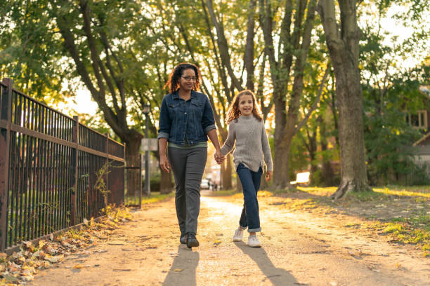 istock Smiling mother and daughter walking in park while holding hands 1218865390