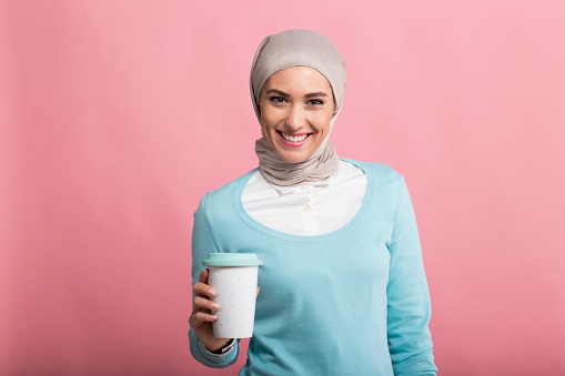Girl holding a coffee and smiling