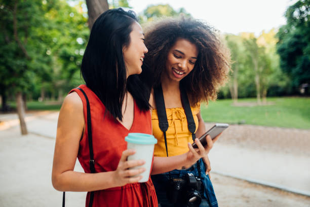 istock Girls on vacation walking together and using mobile app 1218865713