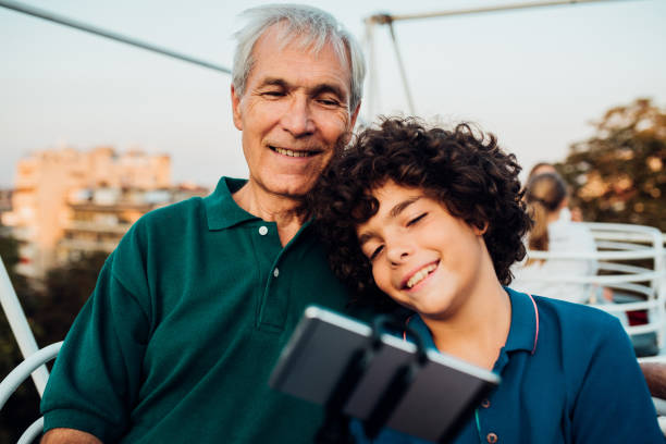 istock Boy having fun with his grandpa and taking a selfie 1218865740