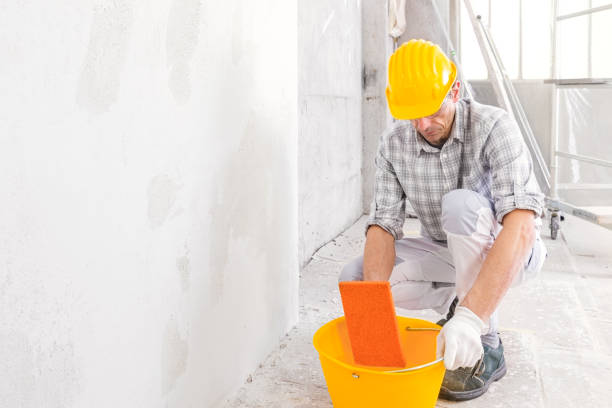 istock Builder damping a sponge in a bucket of water 1218865788