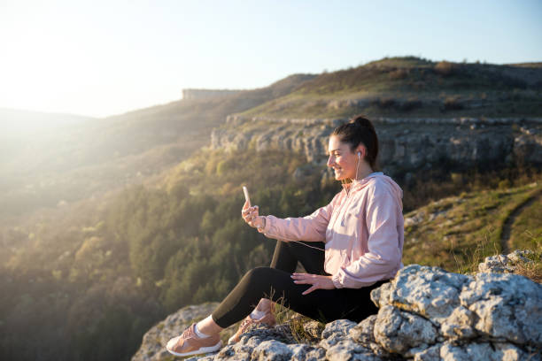 istock Happy young woman hiker taking a selfie on mountain edge 1218866507