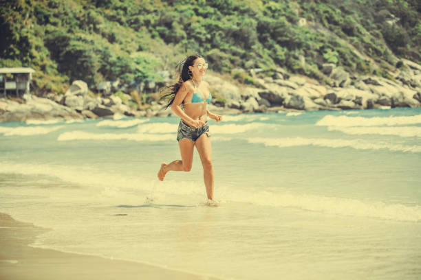 woman in a boho dress walking on the tropical beach