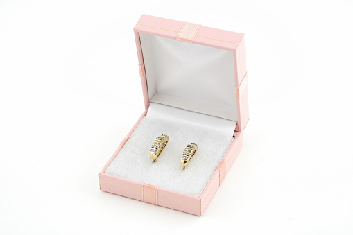 two yellow gold earrings in box on white background