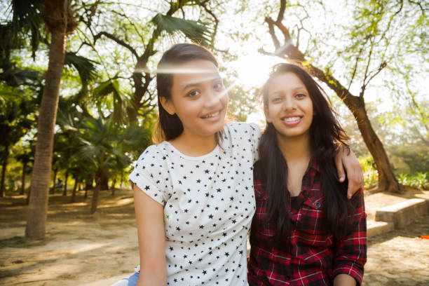 dwie młode dziewczyny za pomocą smartfona zdjęcie stockowe - child asian and indian ethnicities facial expression asia zdjęcia i obrazy z banku zdjęć