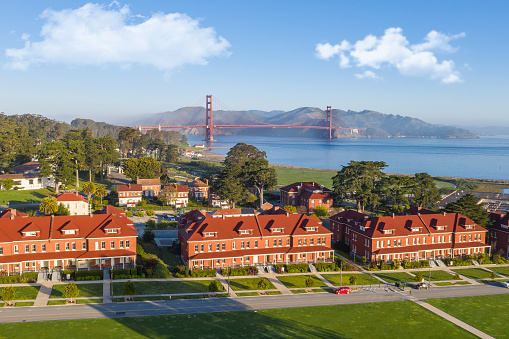 An aerial view of the Golden Gate Bridge and the Presidio. A beautiful blue sky with a hint of low fog.