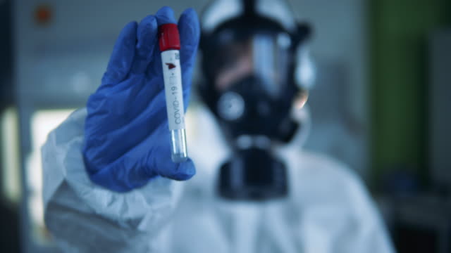Scientist holds a tube with coronavirus vaccine.