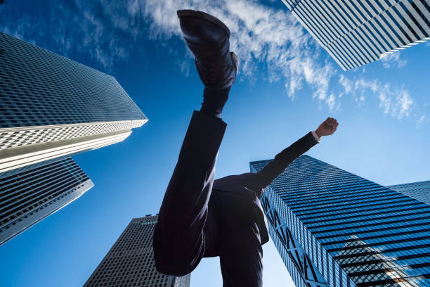 A Japanese male businessman A Japanese male businessman jumping in the city punching the air stock pictures, royalty-free photos & images