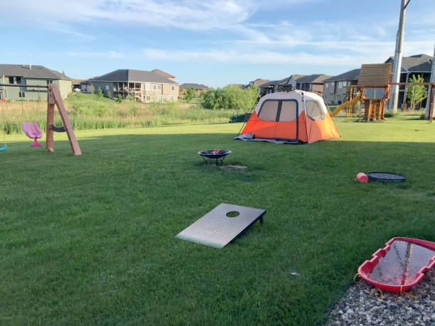 Backyard camping in town with tent, play ground, and fire pit