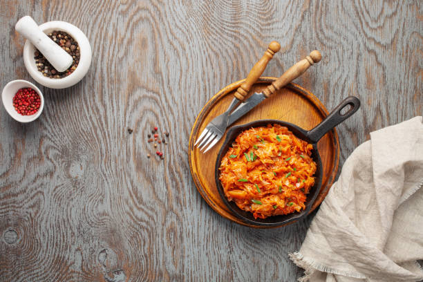 istock Stewed cabbage in skillet on wooden background in rustic style. Top view 1218889525