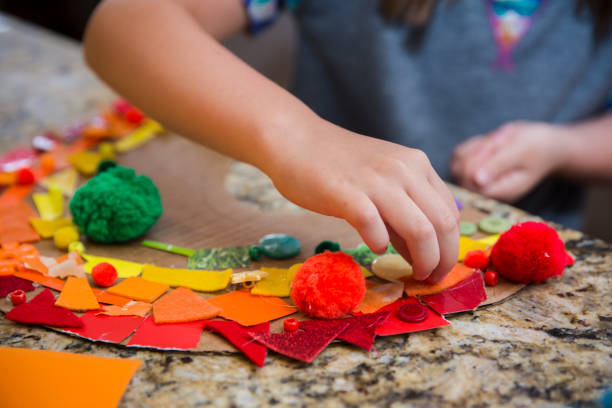 istock Child putting orange felt on a rainbow collage 1218890265