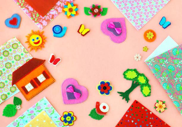Crafts from felt on a pink background. Home, heart, butterfly, sun made of felt. Needlework and hobbies.