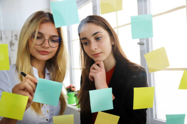 istock Two businesswomen looking at sticky notes 1218894523