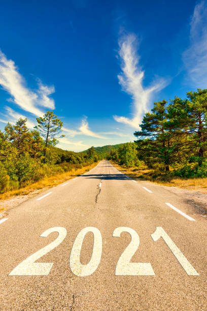 2021年の新年の始まり。美しい風景の中で空の田舎道の番号2021。新年の概念 ストックフォト