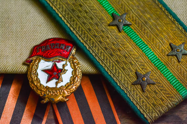 medaglia ed epaulettes di un soldato sovietico della seconda guerra mondiale, sfondo del giorno della vittoria - medal bronze medal military star shape foto e immagini stock