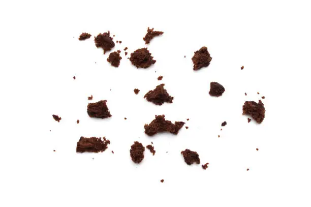 Crumbs of Chocolate brownie with sliced almond nuts toppings isolated on white background.