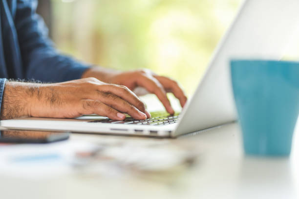 istock Close up male hands using laptop while work from home social distancing concept. Focusing Finger texting keyboard of laptop computer. 1218900360