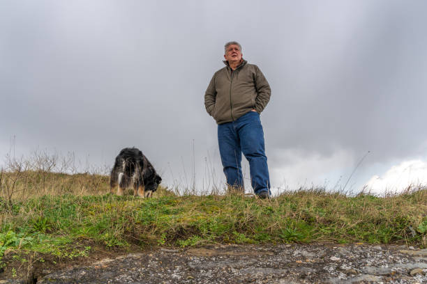 istock Man on grassland with border collie 1218902531
