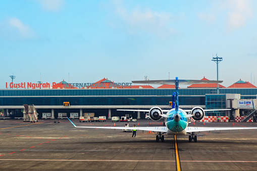 Denpasar, Bali Island, Indonesia - August 31, 2016: Aircraft of national Indonesian air carrier Garuda in front of passenger terminal of Denpasar International Airport Ngurah Rai.