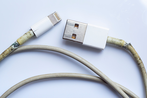 Damaged white usb cable plug and micro usb plug or Old Smart Phone Charger Cable broken on white acrylic background, Close up & Macro shot, Select focus, Technology, Business concept