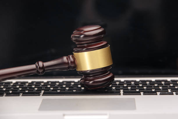 istock Wooden judge hammer on laptop computer white keyboard 1218911437