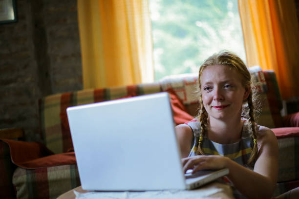 istock Young woman using laptop at home 1218912437