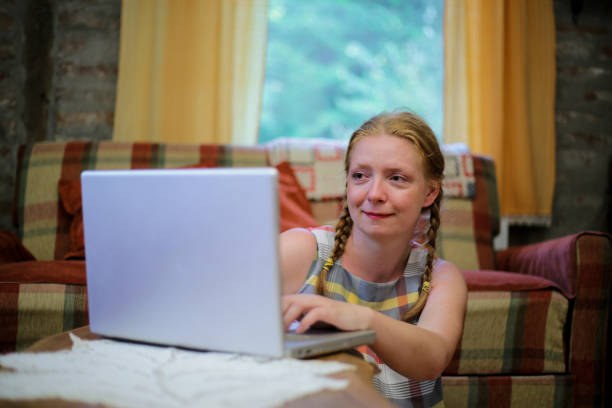 istock Young woman using laptop at home 1218913195