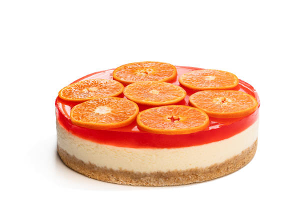 istock Delicious cheese cake with jellied layer and oranges on top isolated on white 1218913332