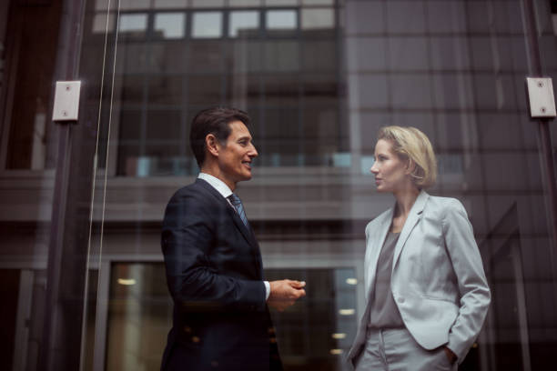 Check this please Two formally dressed executives are working together in the bright office. They are looking at the smart phone. georgijevic frankfurt stock pictures, royalty-free photos & images