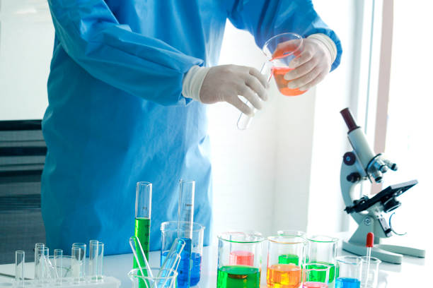 istock Scientist hand doing science experiment, colorful solutions in scientific glassware on table, researcher working in biology and chemistry laboratory concept 1218914348