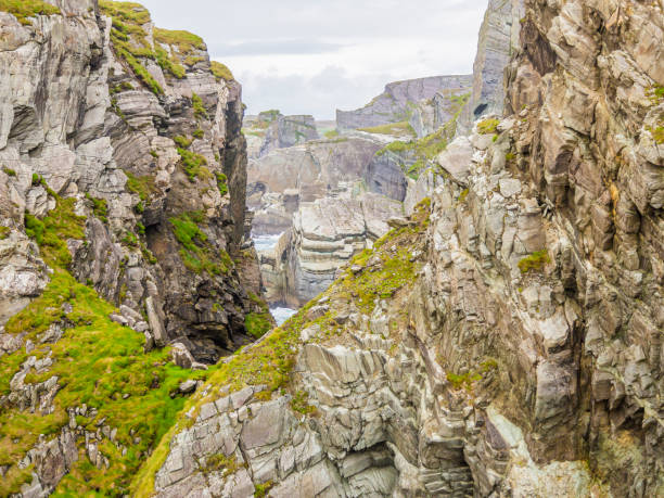 Rough cliff line at Mizen head lighthouse in southern west Ireland during daytime Rough cliff line at Mizen head lighthouse in southern west Ireland mizen head stock pictures, royalty-free photos & images