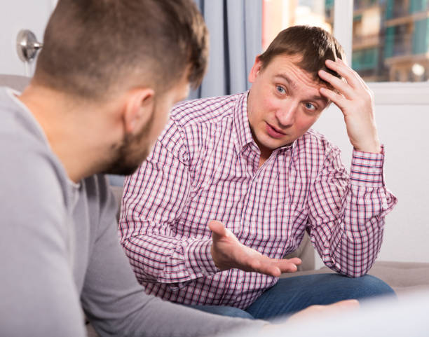 istock Troubled man talking with friend on sofa 1218918323