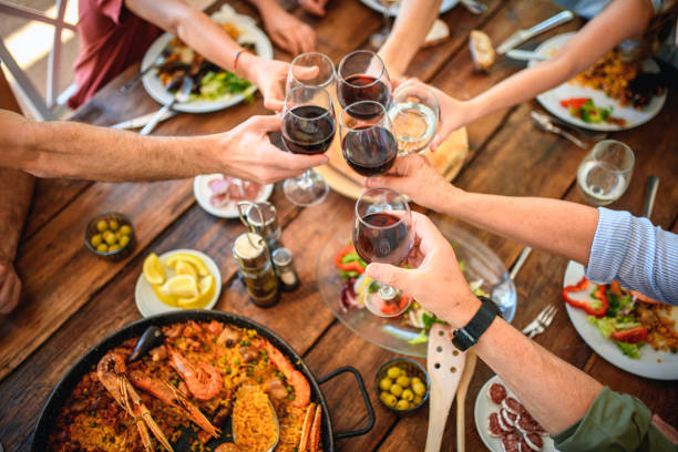 toasten mit rotwein und wasser vor beginn der mittagsmahlzeit - spanisches essen stock-fotos und bilder