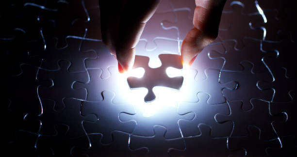 istock A creative completes the white puzzle putting the last missing piece. 1218921214