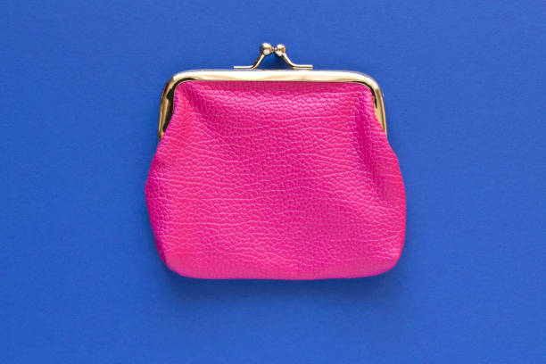 istock Fashionable pink wallet on a blue background. Close up. 1218924729