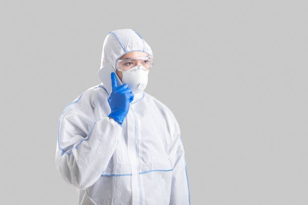 istock Man in protective suit with gloves speaks on phone 1218925283