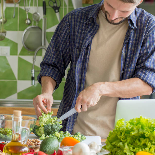 istock Young man preparing Vegetable Salad In Bowl 1218925518