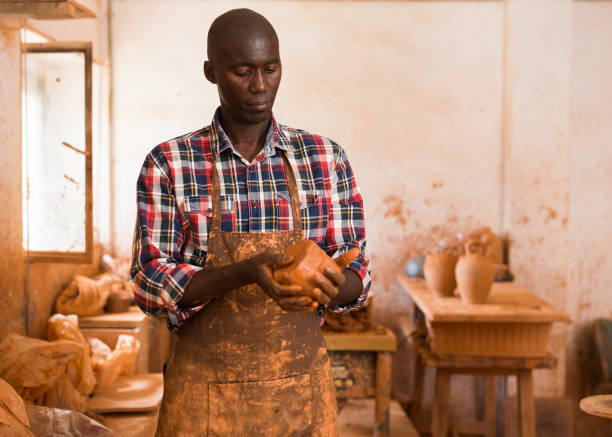 istock Craftsman moulding wet clay in hands 1218926113