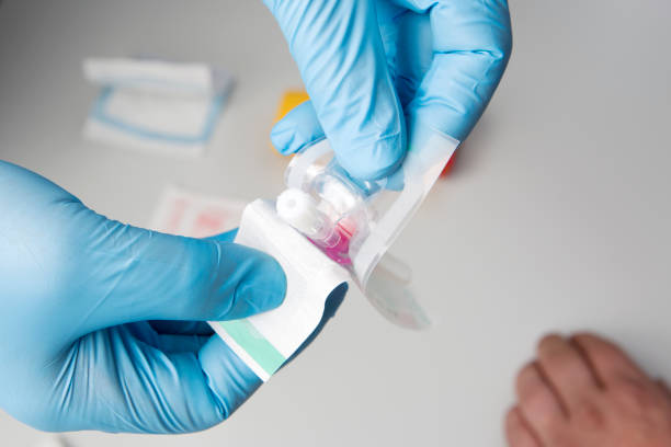 istock First Aid. Preparing to insert an IV, intravenous line. Opening the set 1218933089