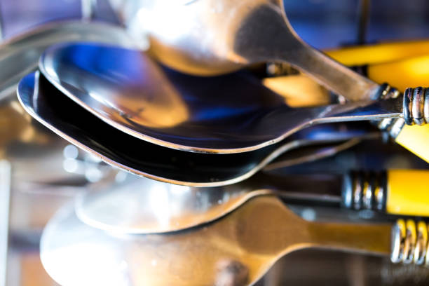 Stack of clean dishes and cutlery on the drying board