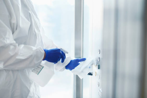 istock Technician disinfecting buttons of the elevator 1218938980