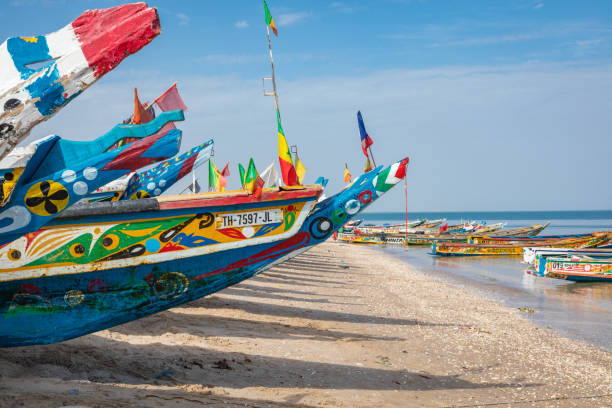 Traditional painted wooden fishing boat in Djiffer, Senegal. West Africa. Djiffer, Senegal - November 17, 2019: Traditional painted wooden fishing boat in Djiffer, Senegal. West Africa. senegal beach stock pictures, royalty-free photos & images
