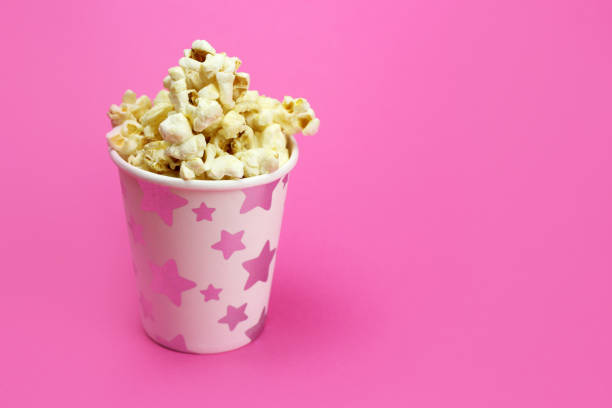 istock caramel popcorn in a paper Cup on a pink background, copy space 1218940477