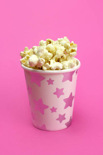 istock caramel popcorn in a paper Cup on a pink background 1218940499
