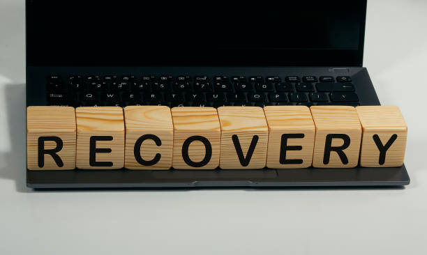 istock RECOVERY written in a wooden cube on a laptop 1218942477