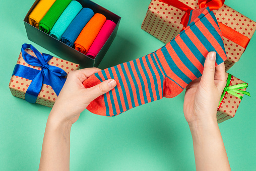 Colorful collection of cotton socks as a gift in woman hands. Gift.