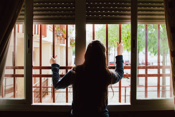 istock woman leaning out of a window during quarantine 1218943809