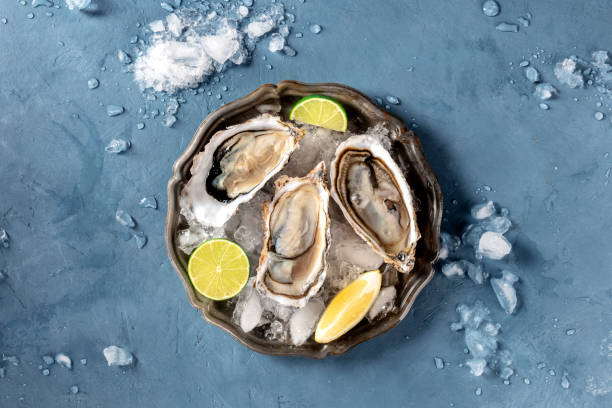 istock Oysters on ice, shot from the top on a slate, with lemon and lime 1218944276