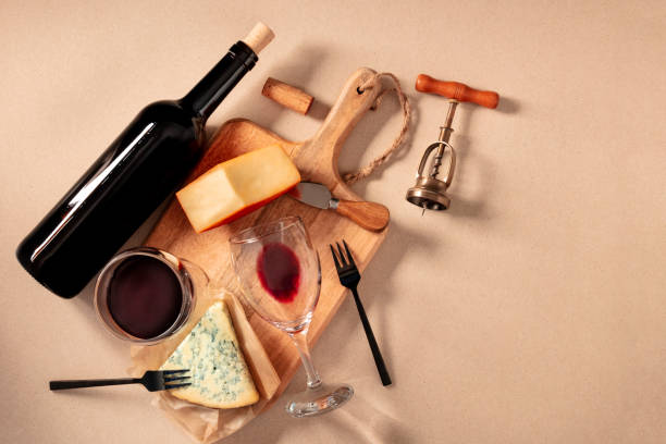 Wine and cheese tasting, top shot on a brown background, with a cork, corkscrew, and a bottle, with a place for text